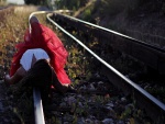 Mujer tumbada sobre la vía de un tren