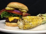 Mazorca de maíz junto a una hamburguesa