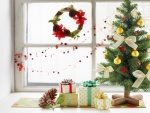 Árbol de Navidad y regalos junto a una ventana
