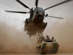 Tanque y helicóptero en una nube de arena