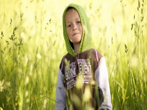 Postal: Un guapo niño entre plantas verdes