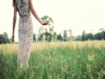 Mujer con un vestido de flores caminando por el campo