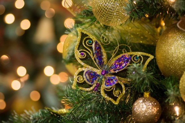 Mariposa y bolas cuelgan del árbol de Navidad