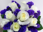 Un delicado ramo con rosas blancas y pequeñas flores color púrpura