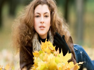 Una mujer con hojas otoñales