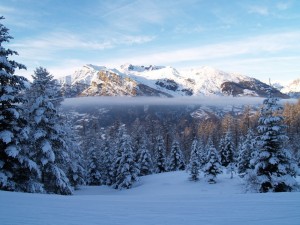 Postal: El sol iluminando las montañas nevadas