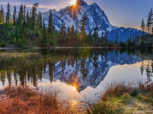 El sol y la montaña reflejados en el lago