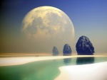 Hombres caminando hacia las rocas con una gran luna en el cielo