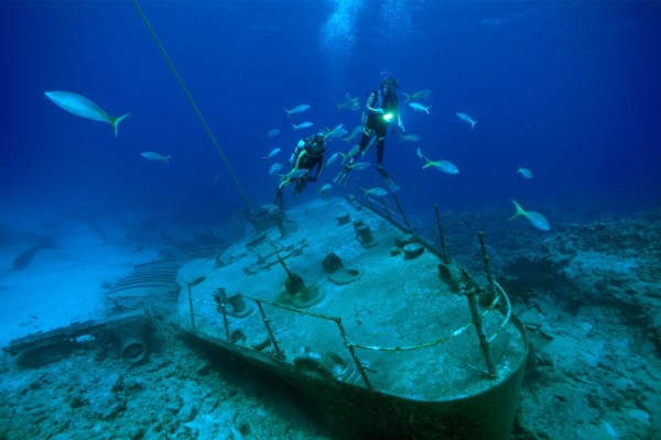 Buzos y peces ciernen sobre los restos de un barco en las Islas Caimán