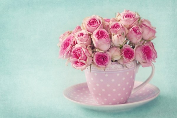Una taza con un ramo de rosas rosadas
