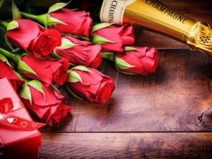 Rosas rojas, regalo y una botella de champán para festejar San Valentín