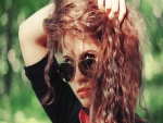 Chica con el pelo rizado y gafas de sol