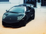 Lamborghini negro junto a una casa