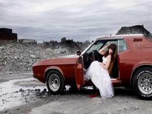 Mujer con vestido de novia sentada en un coche