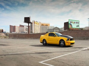 Postal: Mustang amarillo en un aparcamiento solitario