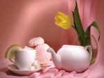 Té y dulces junto a un tulipán amarillo