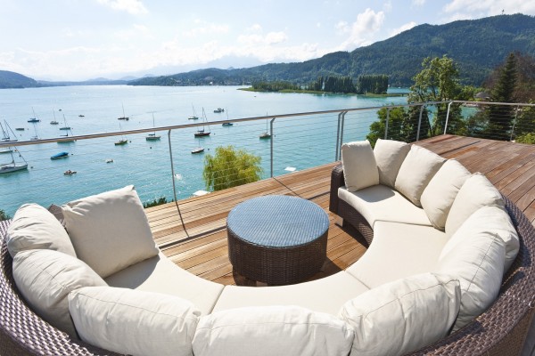 Relajante sofá en una terraza con vistas a un lago