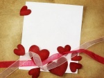 Corazones, cintas y papel para elaborar una tarjeta en San Valentín