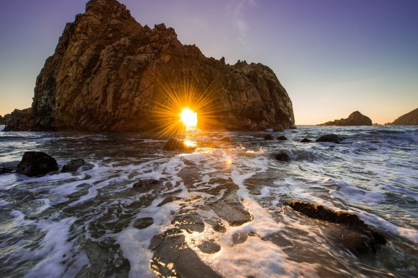 El sol brillando en el hueco de una roca marina
