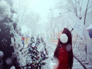 Chica con un paraguas bajo la nieve