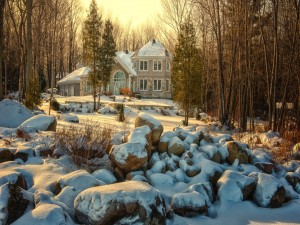 Rocas cubiertas de nieve en el jardín de una gran casa