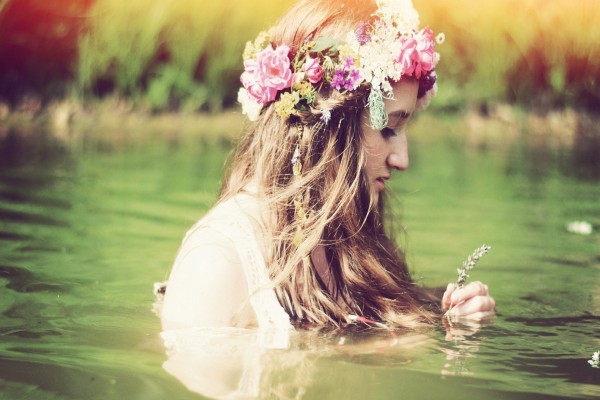 Joven con una corona de flores en el agua
