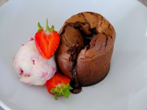 Postal: Un delicioso coulant de chocolate acompañado de helado de fresas