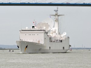 Impresionante embarcación militar navegando bajo un puente