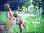 Chica sentada en una silla del jardín