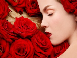 Postal: Bella mujer dormida entre rosas rojas