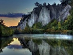 Rocas y árboles reflejados en el agua