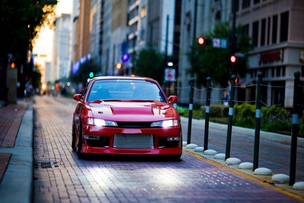 Un coche rojo con las luces encendidas