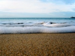 Espuma de mar sobre la arena de una playa