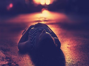 Postal: Mujer tumbada en el asfalto