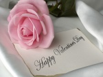 Rosa sobre una nota de ¡Feliz Día de San Valentín!