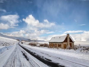Casa junto a una carretera cubierta de nieve