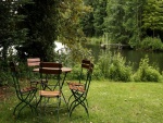 Mesa y sillas en el jardín junto a un bello y tranquilo lago