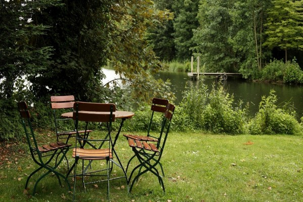 Mesa y sillas en el jardín junto a un bello y tranquilo lago