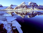 Montañas con nieve reflejadas en el agua