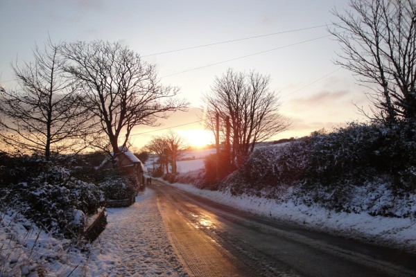 Sol iluminando una carretera en invierno