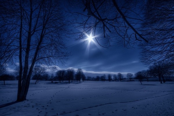 La luna brillando sobre un paisaje cubierto de nieve