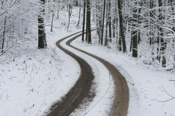 Huellas de coche en una carretera cubierta de nieve