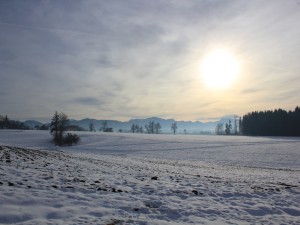 El sol entre las nubes sobre un paisaje cubierto de nieve