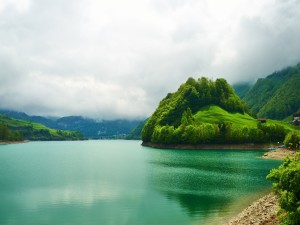 Nubes bajas sobre un lago verde