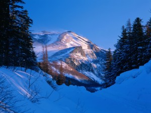 Postal: Sol iluminando la montaña en un frío día de invierno