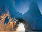 El sol iluminando una pared del iceberg a través de un arco de hielo