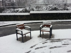 Nieve sobre unos asientos urbanos