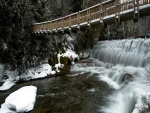 Puente sobre una cascada invernal