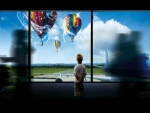 Niño admirando unos globos que vuelan sobre un aeropuerto
