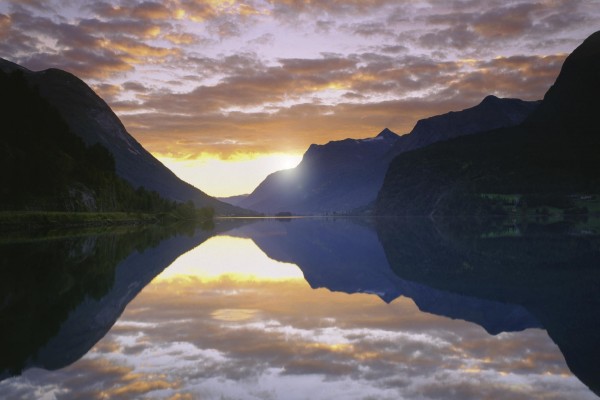 Sol al amanecer reflejado en un lago